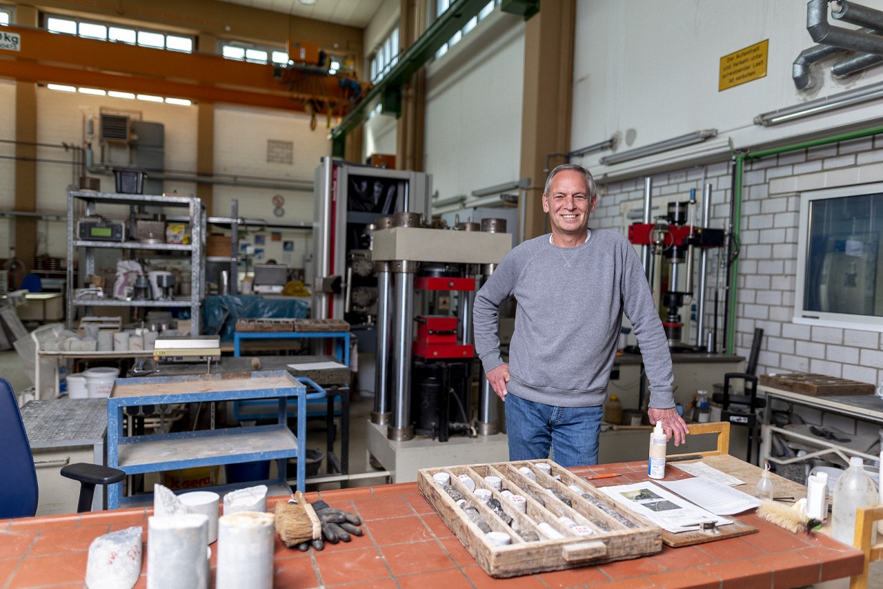 Mitarbeiterfotografie stärkt Teamgeist und somit ihr Unternehmen Porträt eines Mitarbeiters in einer Lagerhalle mit freundlichem Lächeln
