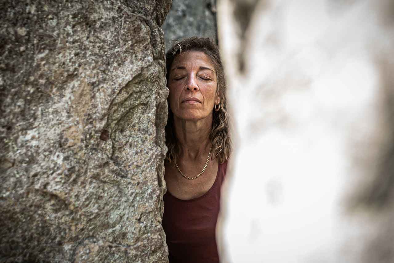 frau mit geschlossenen augen zwischen felsen, in einem moment der stille