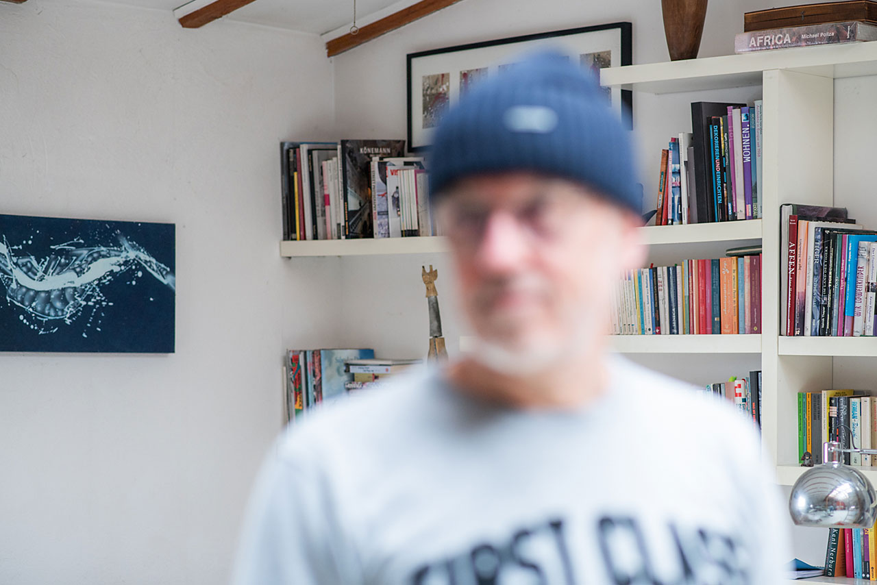 Mann mit Brille in unscharfem Porträt vor Bücherregal, Fotografie Trends 2026 Teaser.