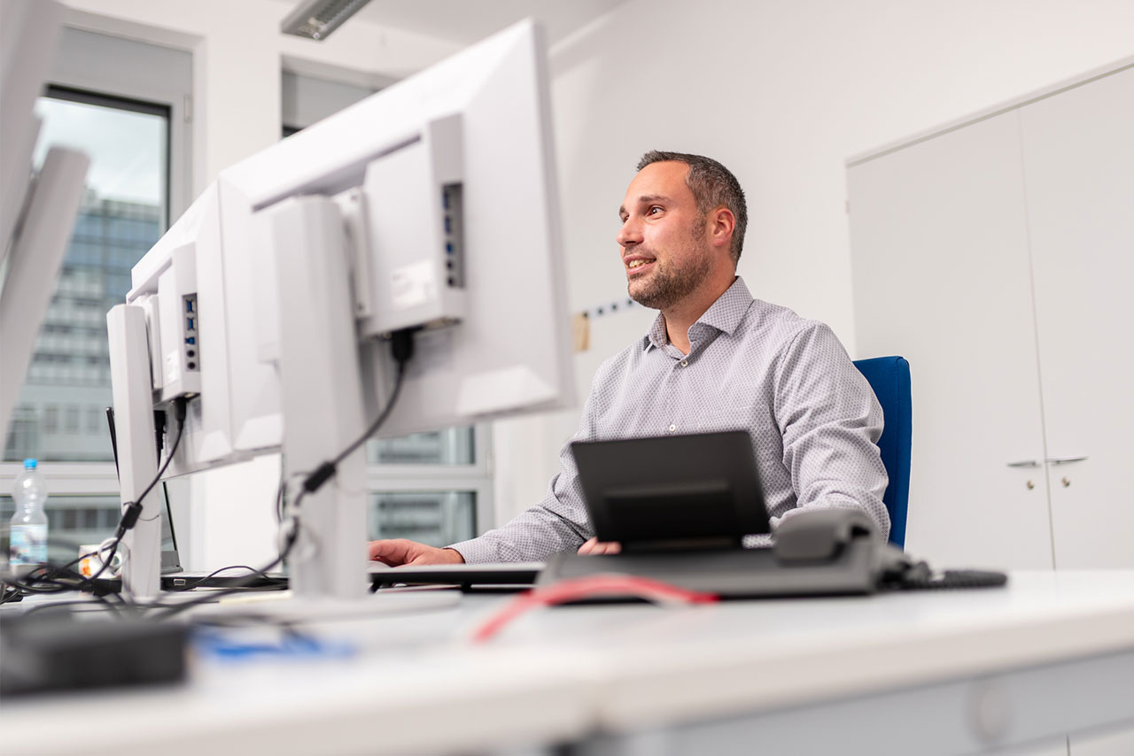 Mitarbeiterfoto im Büro: Mitarbeiterporträt am Schreibtisch, ansprechbar und nahbar